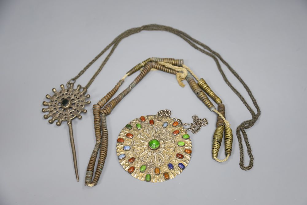 A South American poncho pin, a Turkoman paste and metal medallion and a West African tribal necklace